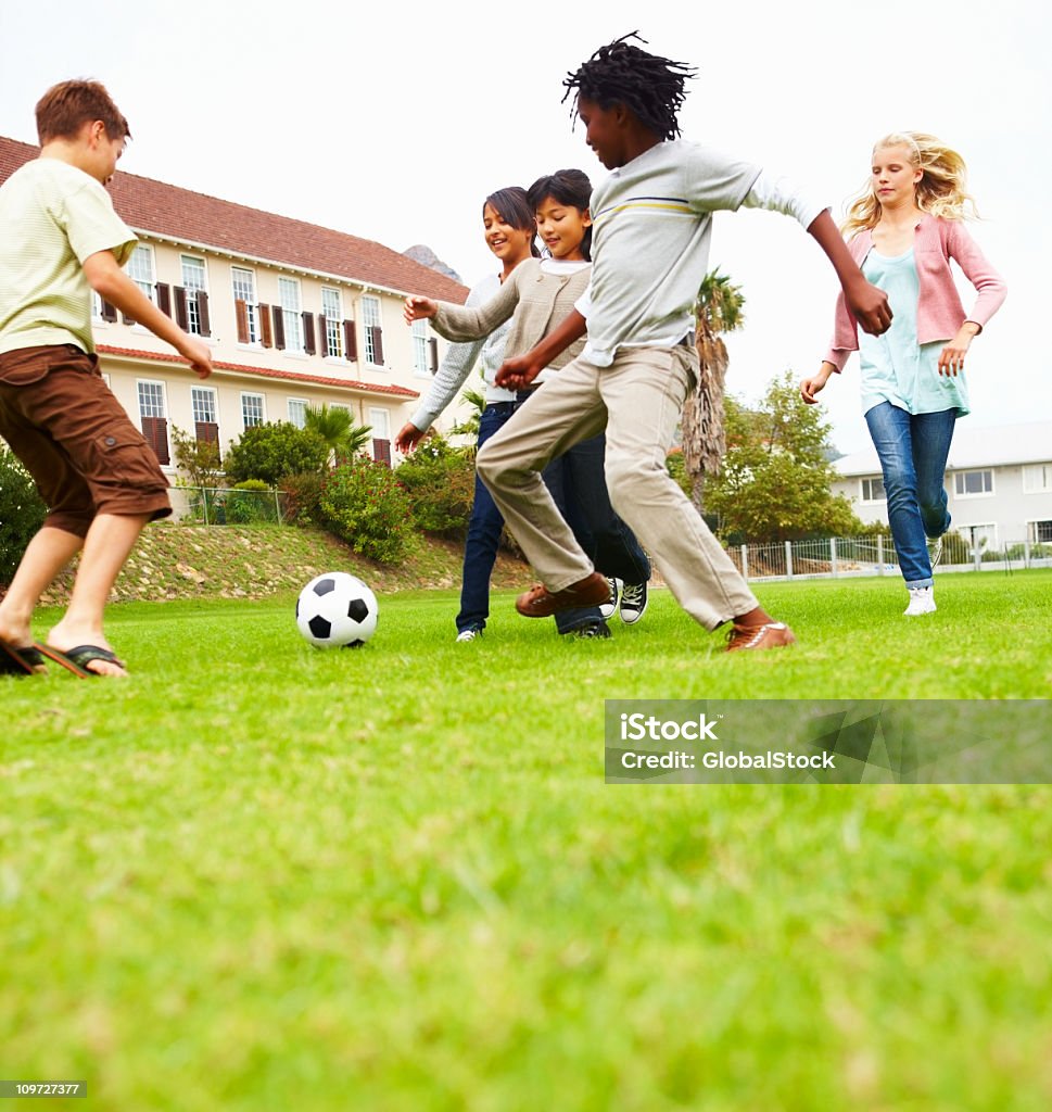 ボーイズアンドガールズがフットボールの公園 - 10歳から11歳のロイヤリティフリーストックフォト