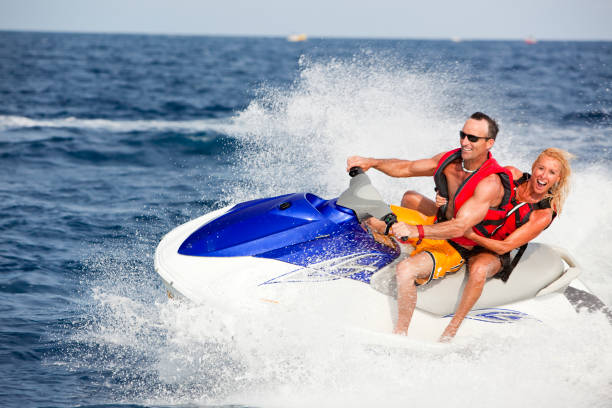 Excited couple riding jetski stock photo