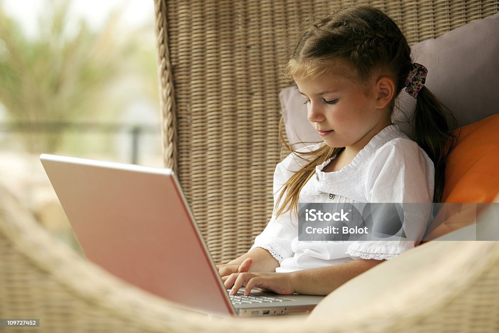 Petite fille à l'aide d'ordinateur portable en plein air - Photo de Enfant libre de droits