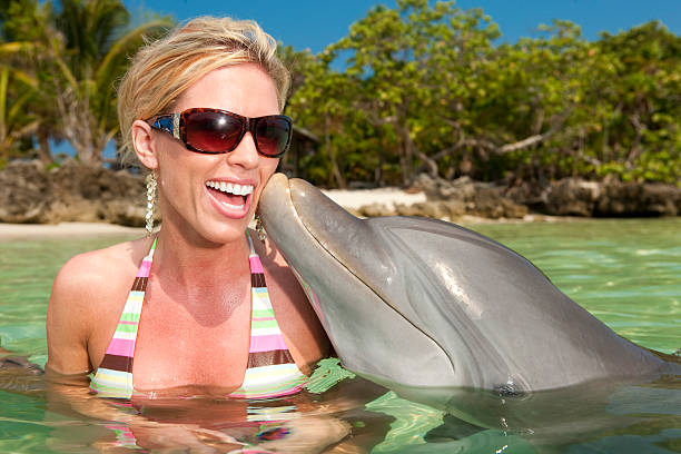 istock Vacation Lifestyles-Dolphin Kissing Woman's Cheek 109727457