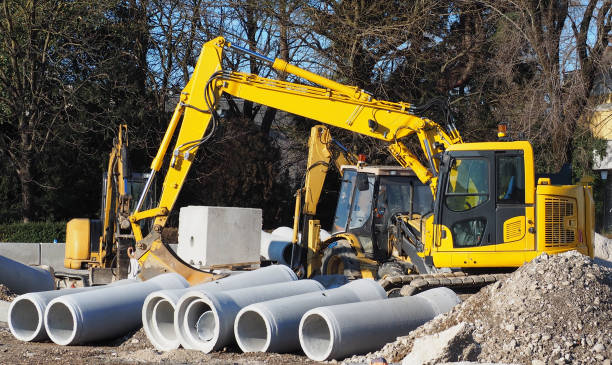 istock Digger, mini excavator and dozer in a road construction site. Pipes concrete precast in front 1097274582