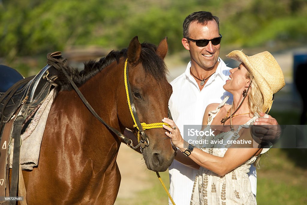 Vacanza stile di vita-Coppia a cavallo - Foto stock royalty-free di Abbigliamento casual