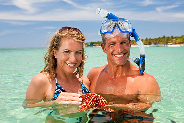 Attractive couple holding starfish stock photo