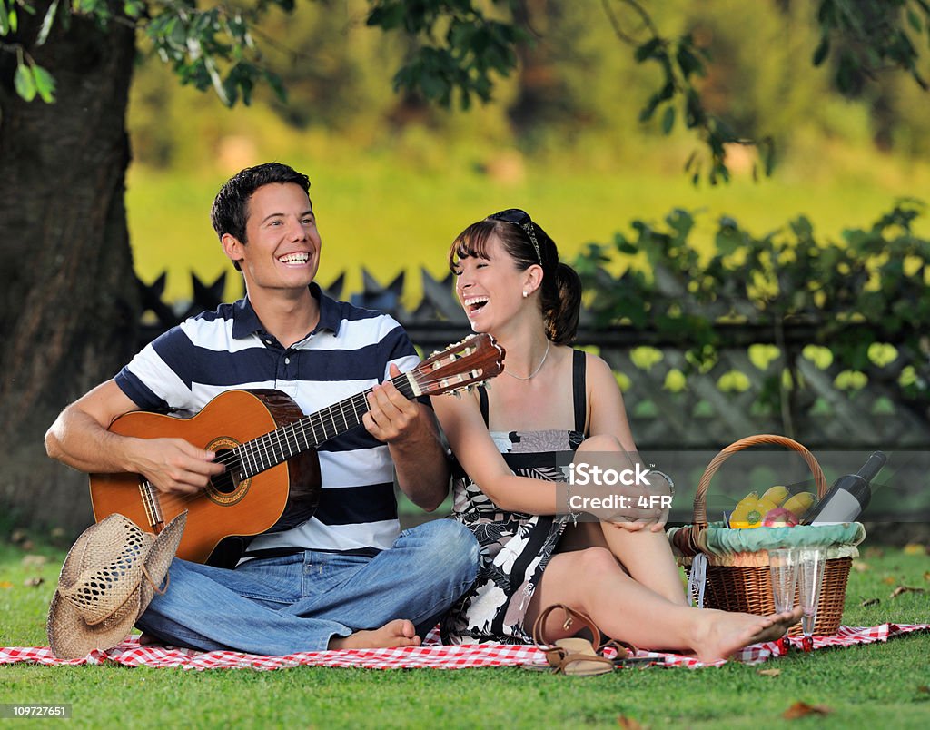 Couple ayant un pique-nique dans la meadows, jouer de la guitare (XXXL - Photo de Guitare libre de droits