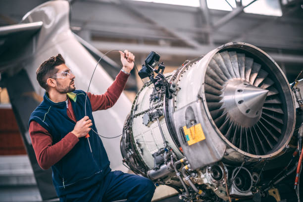 istock Aircraft mechanic probing an opened jet engine of an airplane with a portable camera and looking at the monitor in the maintenance hangar 1097276708