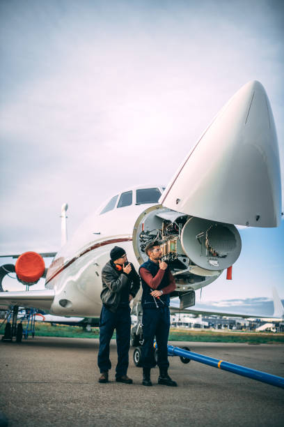 istock Two aircraft engineers working on a sensor and radar array under the nose cone of a private airplane parked on an airport tarmac 1097279298