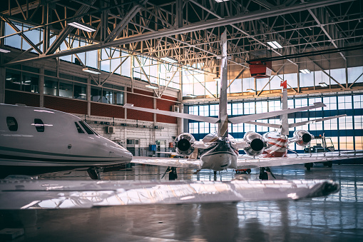 Small airplanes parked in a hangar.