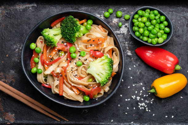 asiatische wok mit udon-nudeln und gemüse - bamboo brown cooking gourmet stock-fotos und bilder