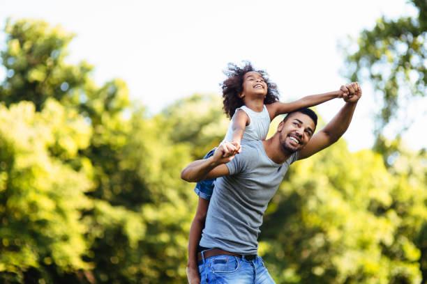 Portrait of young father carrying his daughter on his back Portrait of young father carrying his daughter on his back in nature half dressed girls pictures stock pictures, royalty-free photos & images
