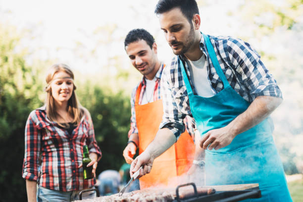 istock Young people grilling outdoors and smiling happy 1097282650
