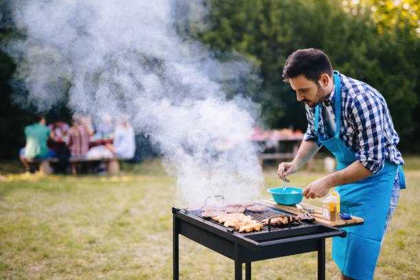 istock Happy male preparing bbq meat in park 1097282704