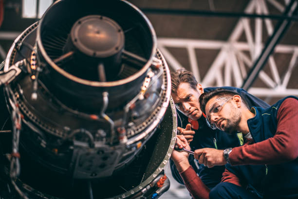 istock Aircraft mechanics repairing together a small private airplane's jet engine 1097282980