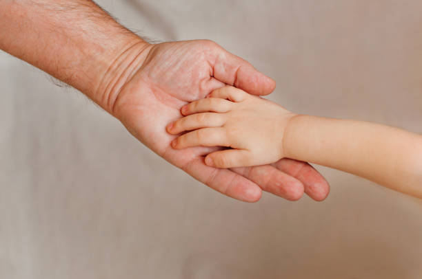 istock Kids hand over grandfather's hand on light background 1097283108