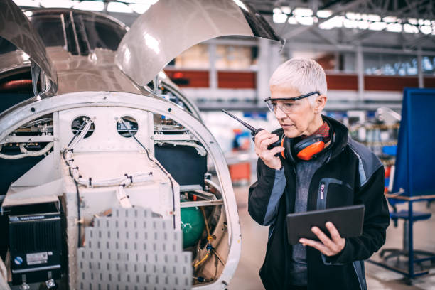 istock Female aircraft engineer checking the sensor array of an airplane while using a radio to communicate with her colleagues. 1097287306
