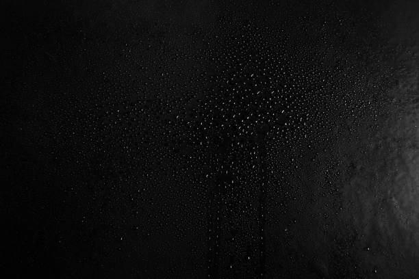 istock Drops of water on a dark glass texture background 1097293294