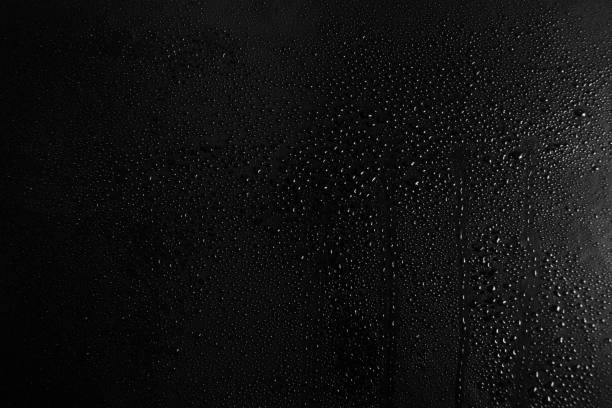 istock Drops of water on a dark glass texture background 1097293318