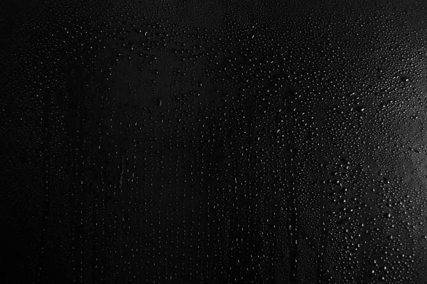 istock Drops of water on a dark glass texture background 1097293356