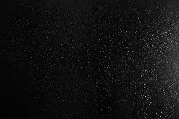 gotas de água sobre um fundo de textura de vidro escuro - condensation water drop glass - fotografias e filmes do acervo