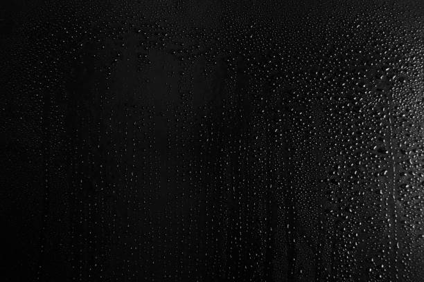 istock Drops of water on a dark glass texture background 1097293406