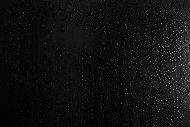 istock Drops of water on a dark glass texture background 1097293450