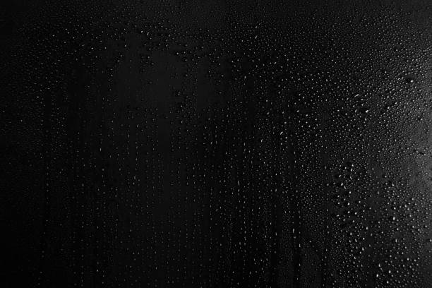 istock Drops of water on a dark glass texture background 1097293528