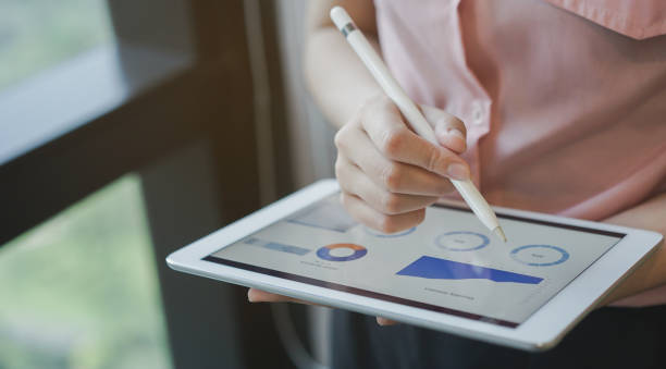 da vicino la mano di manager donna d'affari utilizzando la penna stilo per scrivere o commentare il tablet dashboard dello schermo nella situazione di riunione sulle prestazioni dell'azienda, la tecnologia e il concetto di strategia aziendale - stock market finance investment stock ticker board foto e immagini stock