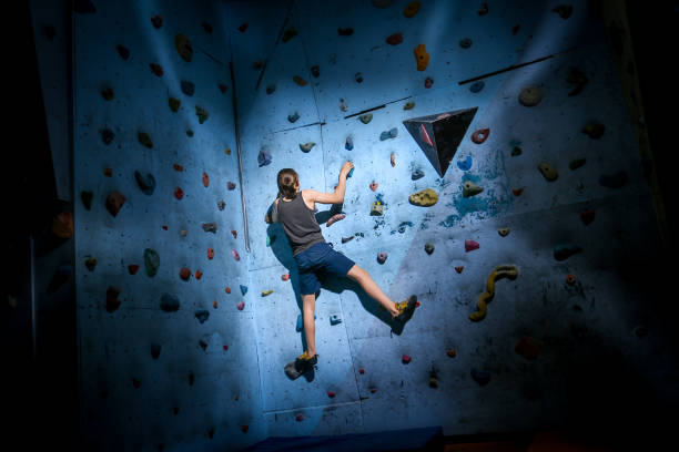 adolescente formação escalada na parede de escalada indoor - climbing wall rock climbing holding reaching - fotografias e filmes do acervo