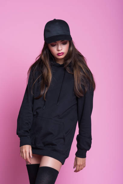 istock Pensive young woman in black clothes against pink background 1097299540