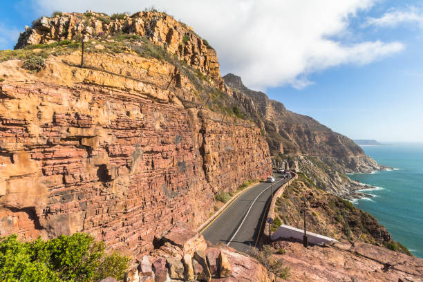 Road leading toward Table mountain in the background with blue sky and clouds