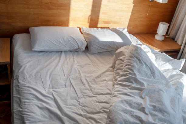 istock untidy bed and two pillows in the morning sun 1097305040