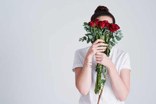 Beautiful young asian woman florist cutting rose flower in flower shop