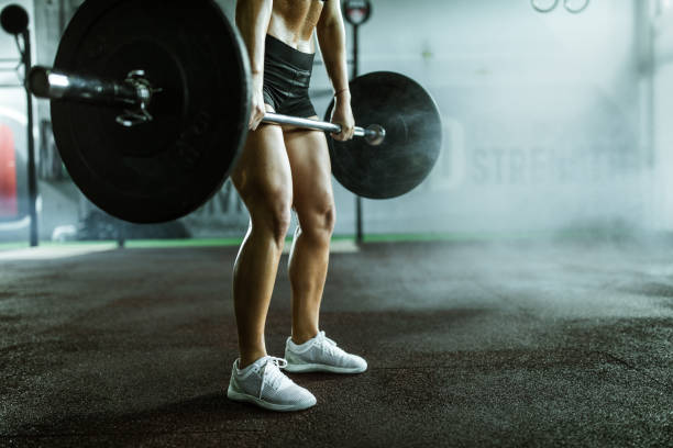 istock Unrecognizable female athlete lifting barbell in a gym. 1097316888