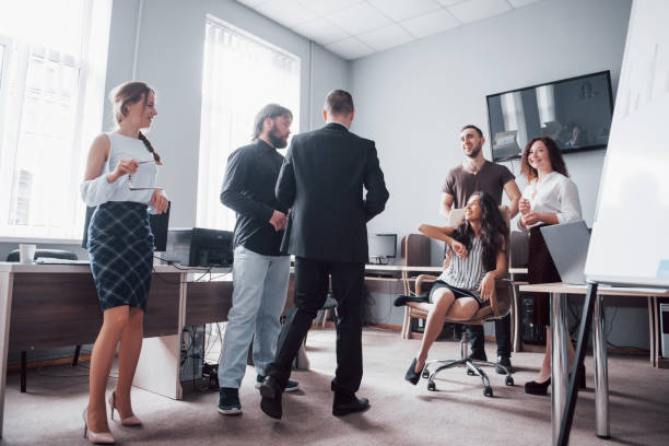 A group of business people celebrating, having fun, at the office. A group of business people celebrating, having fun, at the office friday stock pictures, royalty-free photos & images
