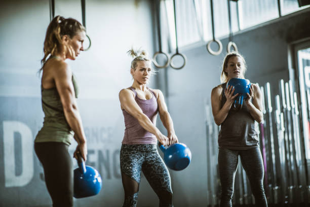 istock Young athletic women exercising with kettle bells in a gym. 1097318870