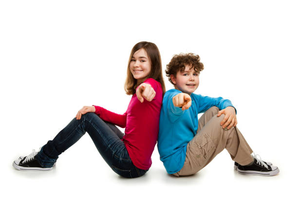 A boy and girl that appear to be siblings are cuddling and showing great affection for each other. The boy is smiling with his eyes closed while the girl looks at the camera.