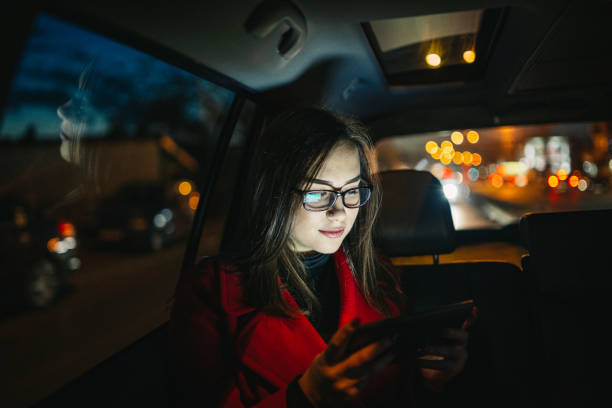 Beautiful young woman using smart phone in car