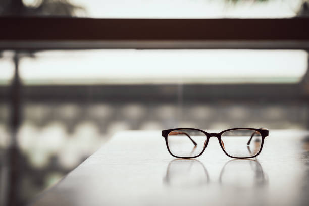 Pink classic eye glasses  on wooden table.
