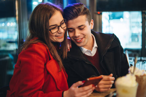 istock Cute young couple using phone in coffee shop 1097324744