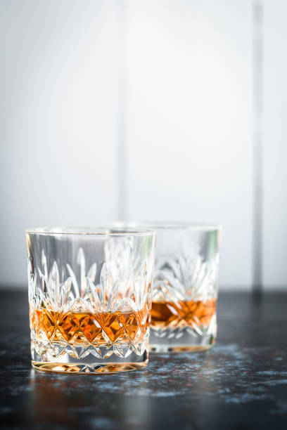 copas de cristal de whisky en la superficie erosionada - barra escocia fotografías e imágenes de stock