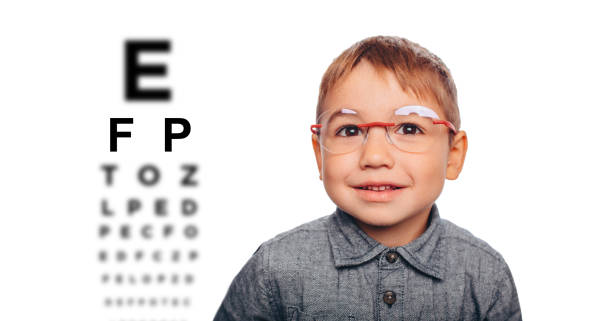 istock Little boy testing new eyeglasses, on the eye chart background 1097329558