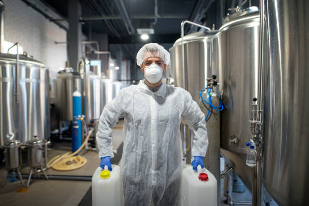 istock Industrial worker holding plastic cans with chemicals in production plant. Technologist wearing protection white uniform handling with aggressive chemicals substances. 1097331480