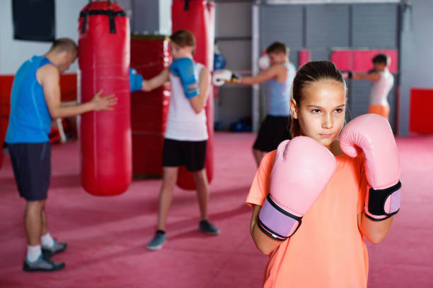 istock Girl in gloves posing during boxing training at gym 1097332104