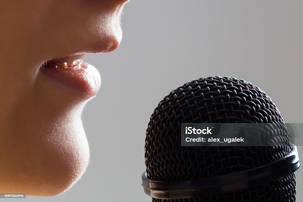 Singing courses background Close-up woman singing with microphone. Music school or singing courses background. Microphone Stock Photo