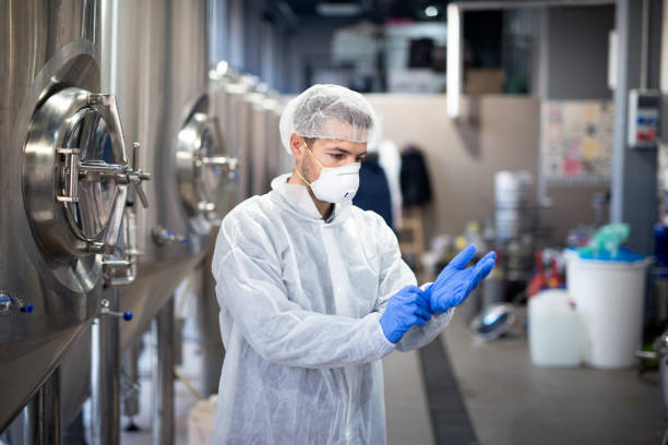 istock Young technologist putting on protective rubber gloves in production factory. 1097333080