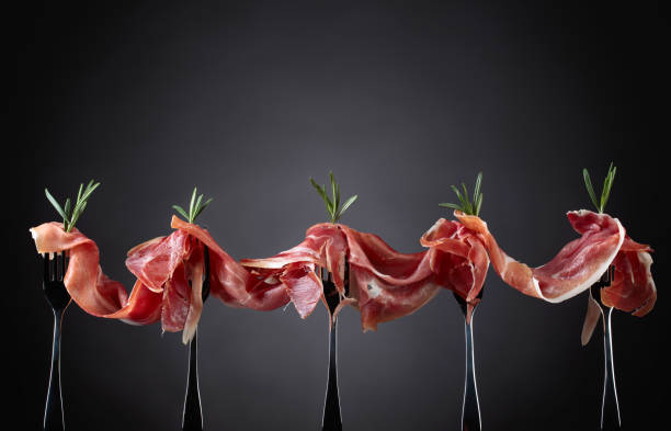 istock Prosciutto with rosemary on a dark background. 1097335350