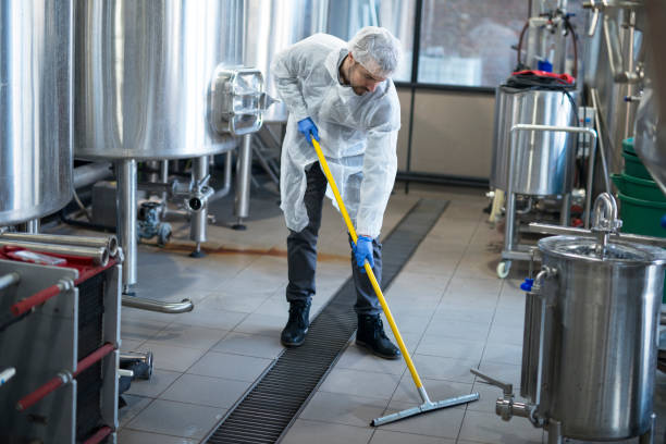 servicio de limpieza industrial. profesional limpiador usando protección uniforme limpieza de piso de planta de producción. - scrub brush fotografías e imágenes de stock