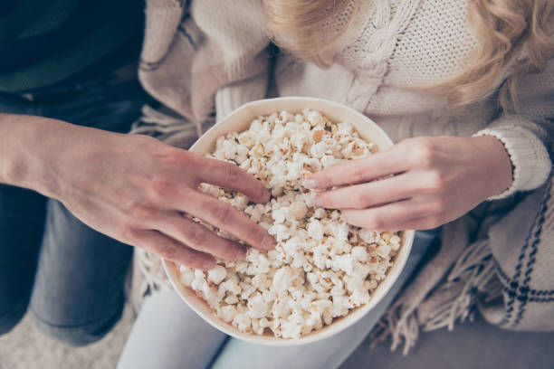 istock Cropped close-up top above high angle view of two hands taking popcorn big large corn box calories junk food in cozy comfort place 1097335632
