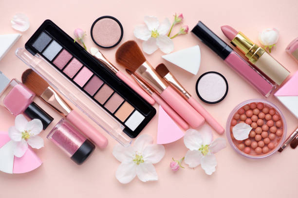 istock Makeup brush and decorative cosmetics with apple blossom on pink background. Top view 1097339070