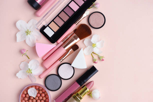 istock Makeup brush and decorative cosmetics with apple blossom on pink background. Top view 1097339082