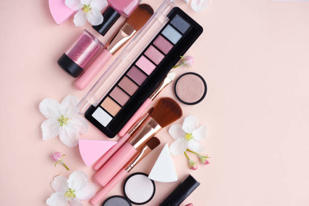 istock Makeup brush and decorative cosmetics with apple blossom on pink background. Top view 1097339110